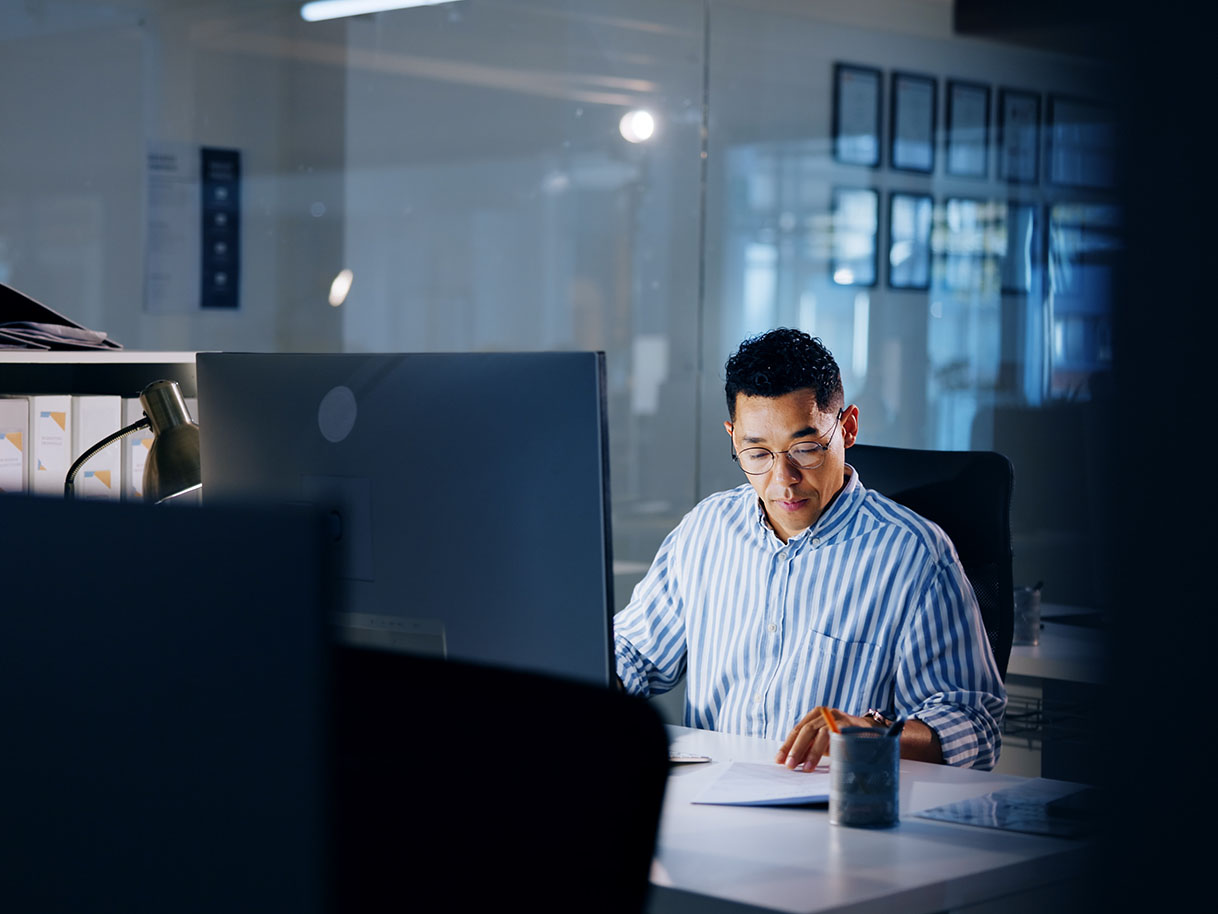 man reading document at desk